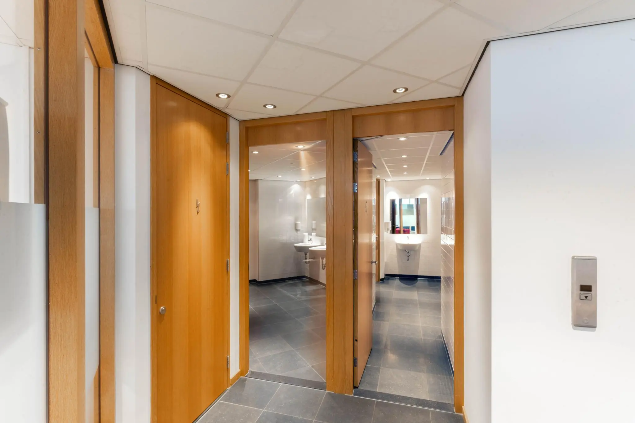 Hal met toegang tot moderne toiletruimtes in een kantoorpand aan de 1e Hogeweg.